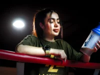 Mulher jovem segurando um shake de whey.